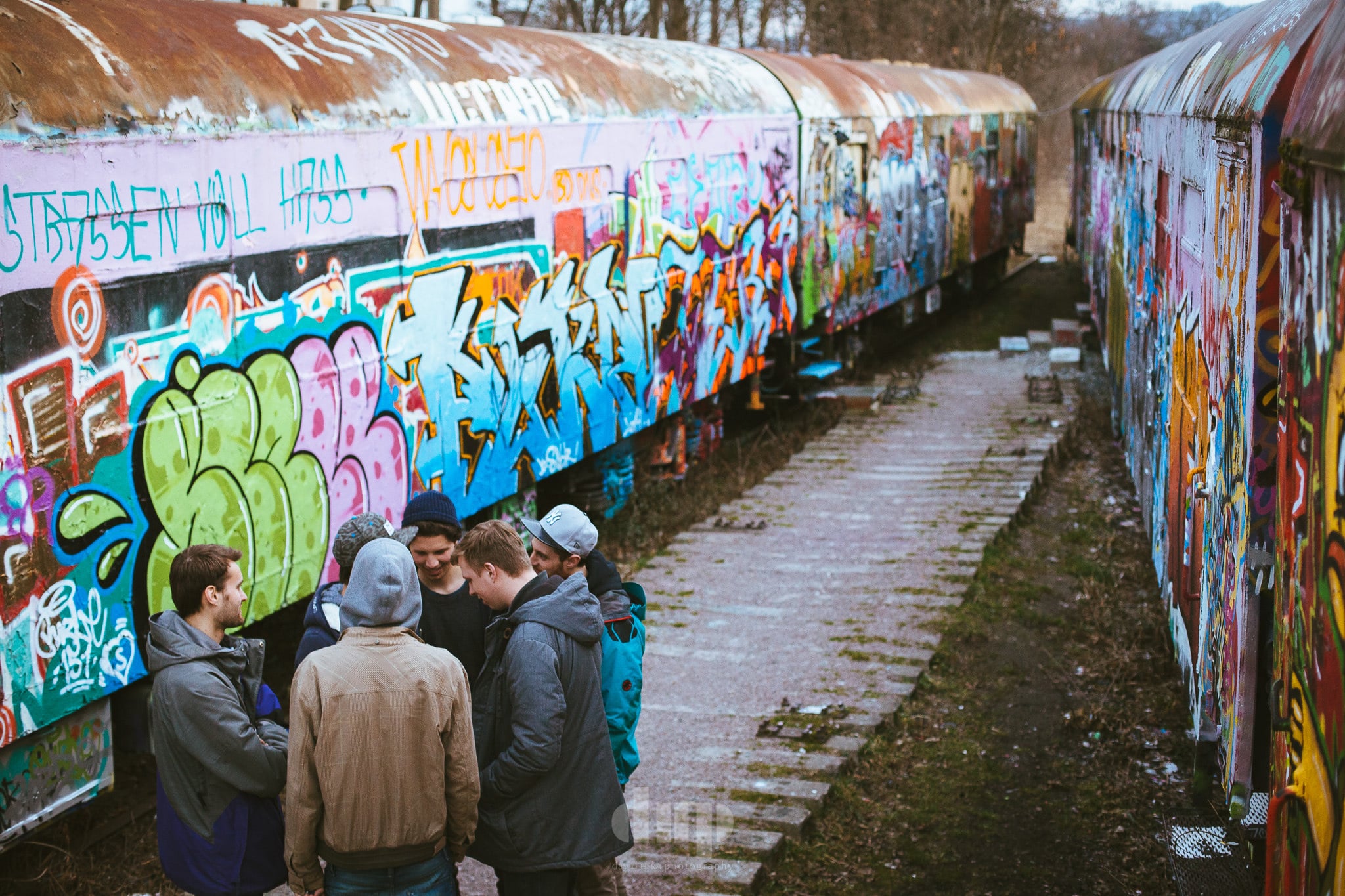 Group gathered beside a graffiti-covered train.