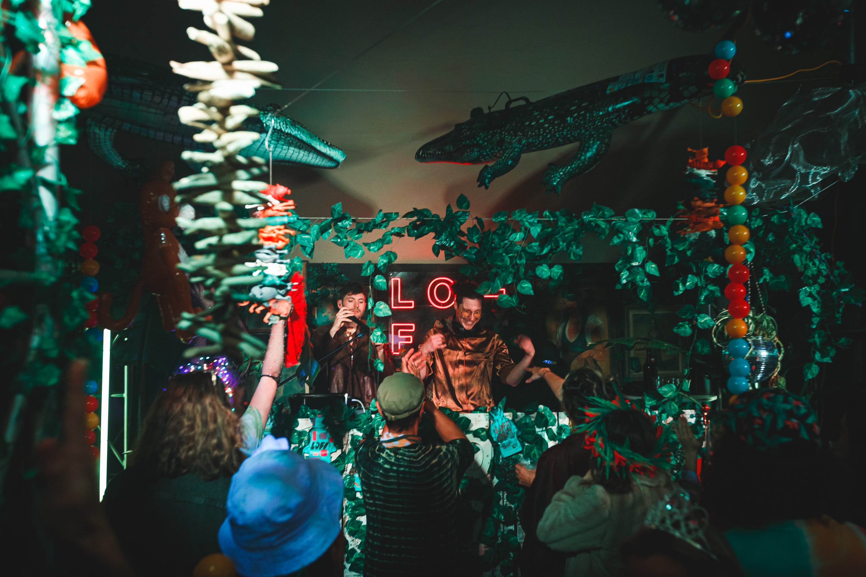 Packed dance floor inside a jungle-themed venue.