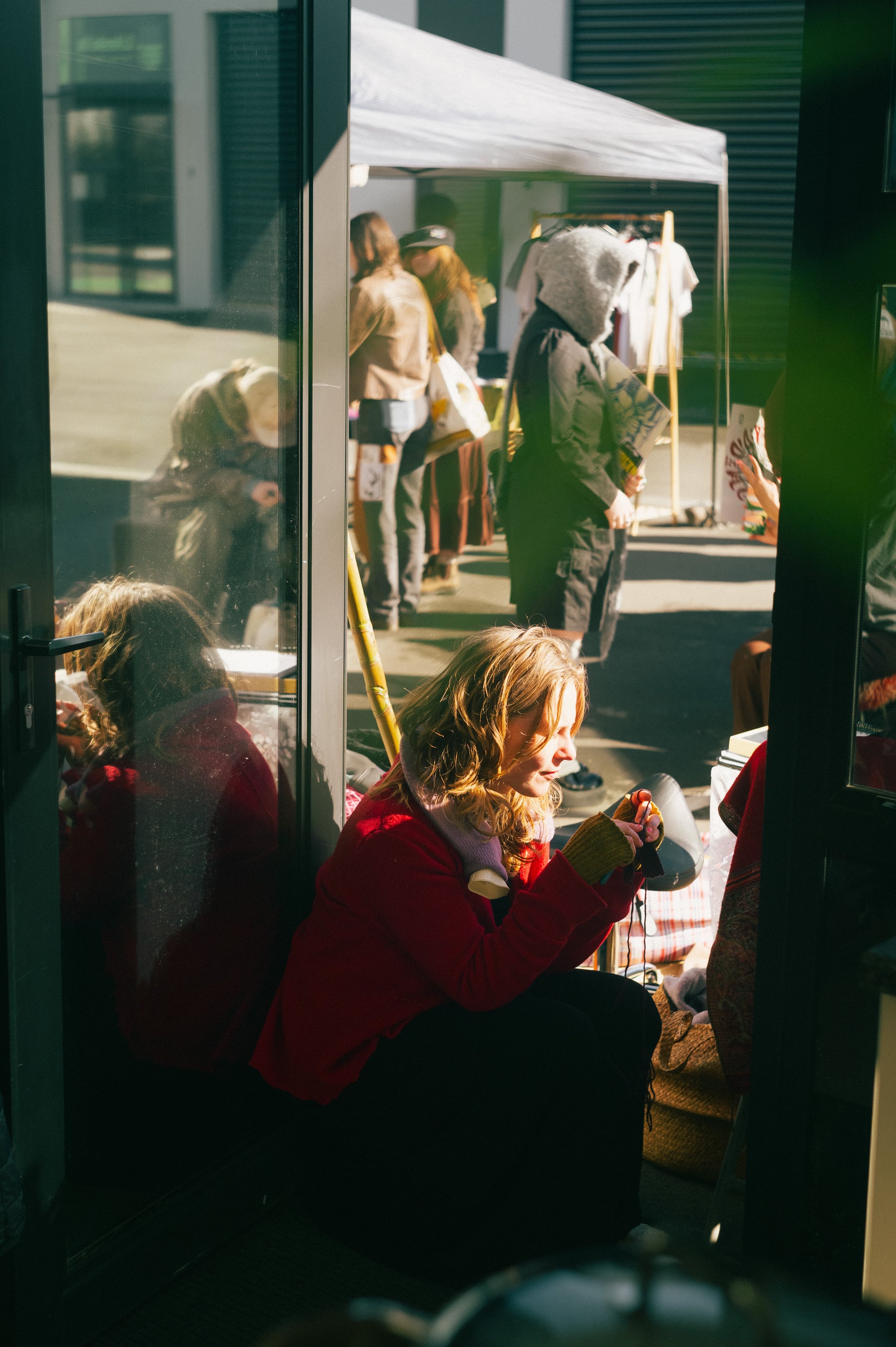 Market stall reflected in a shopfront window.