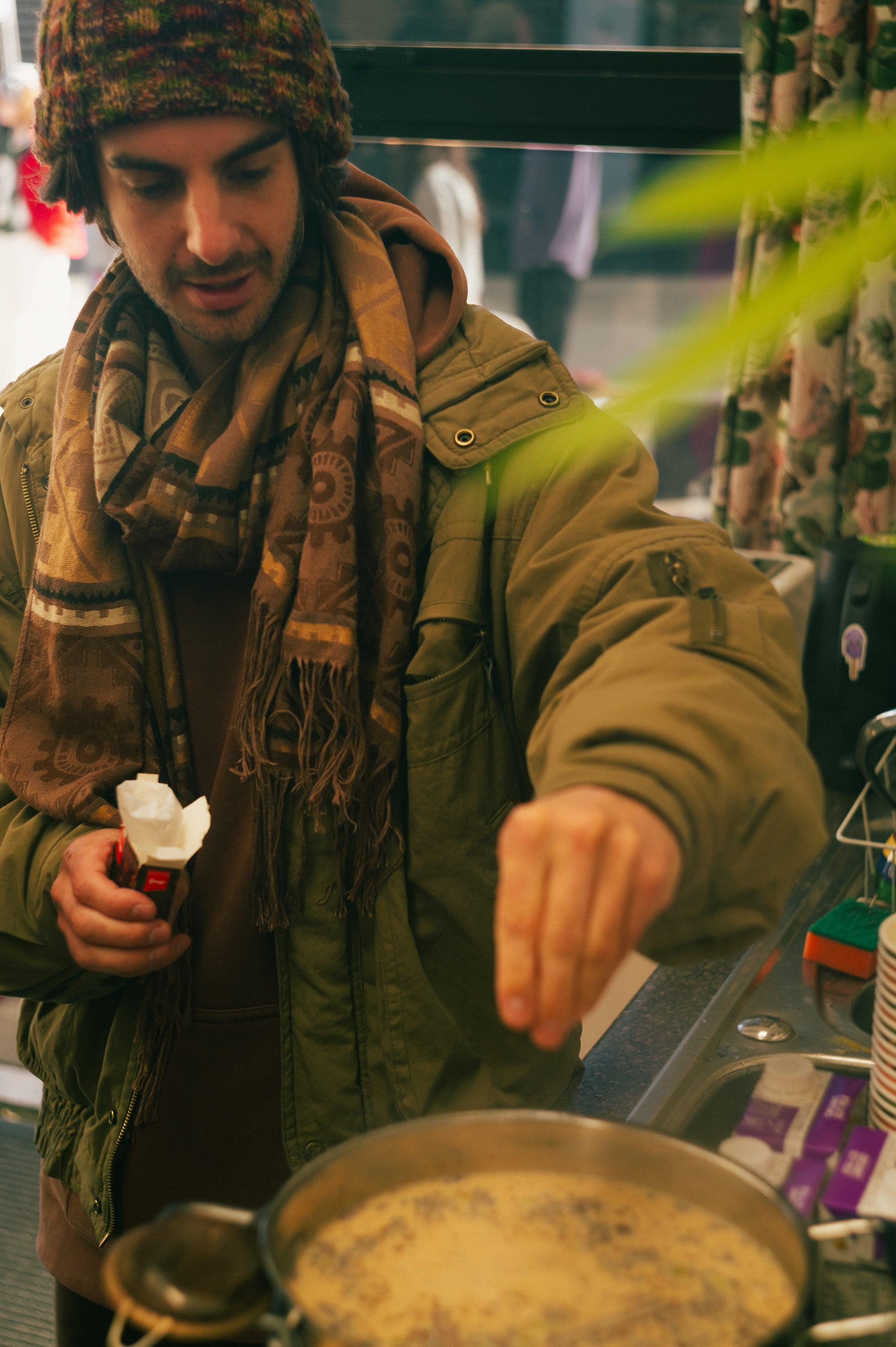 Stallholder serving from a pan at a market food stall.