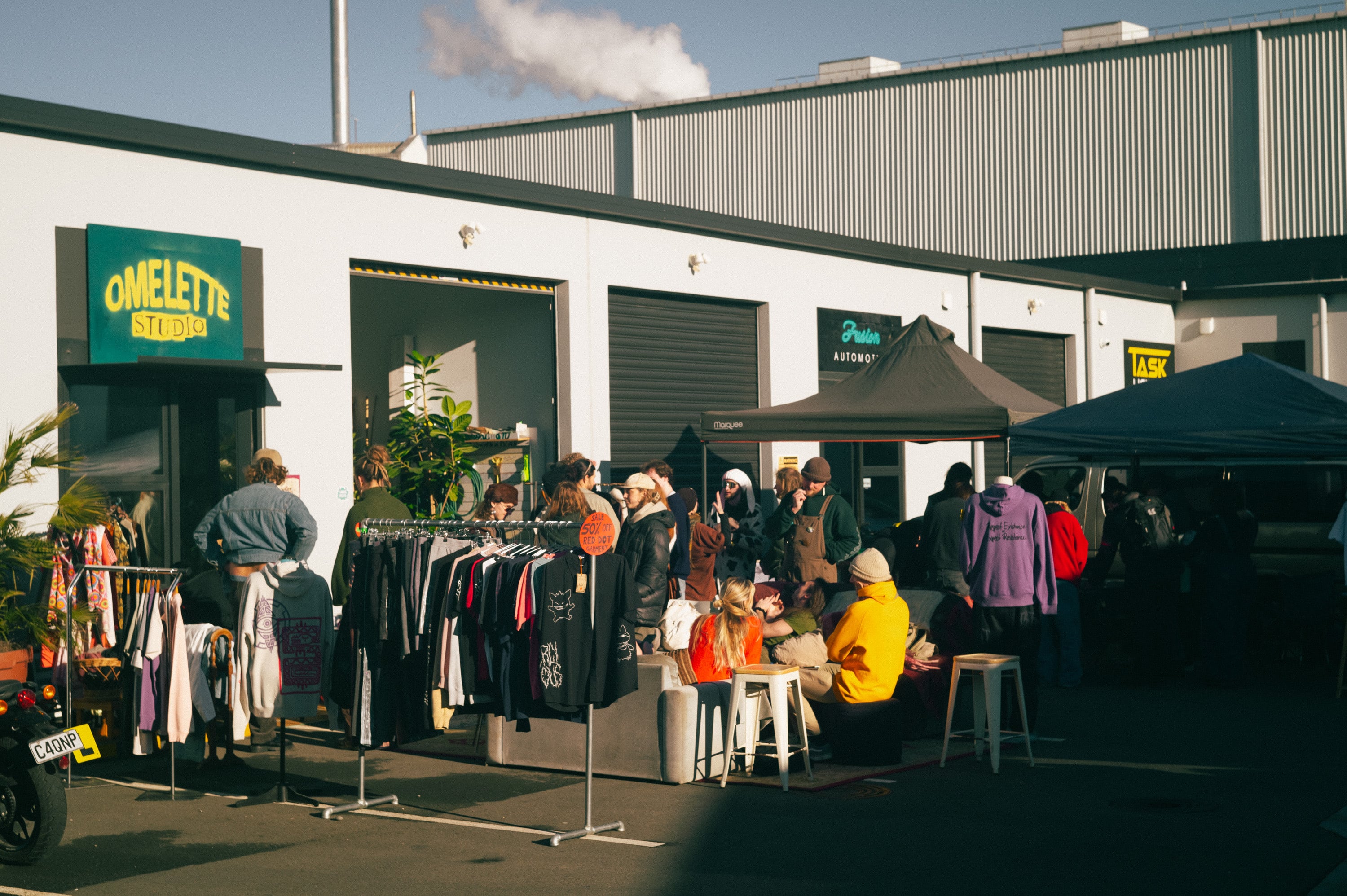Crowd at an outdoor market outside a warehouse café.