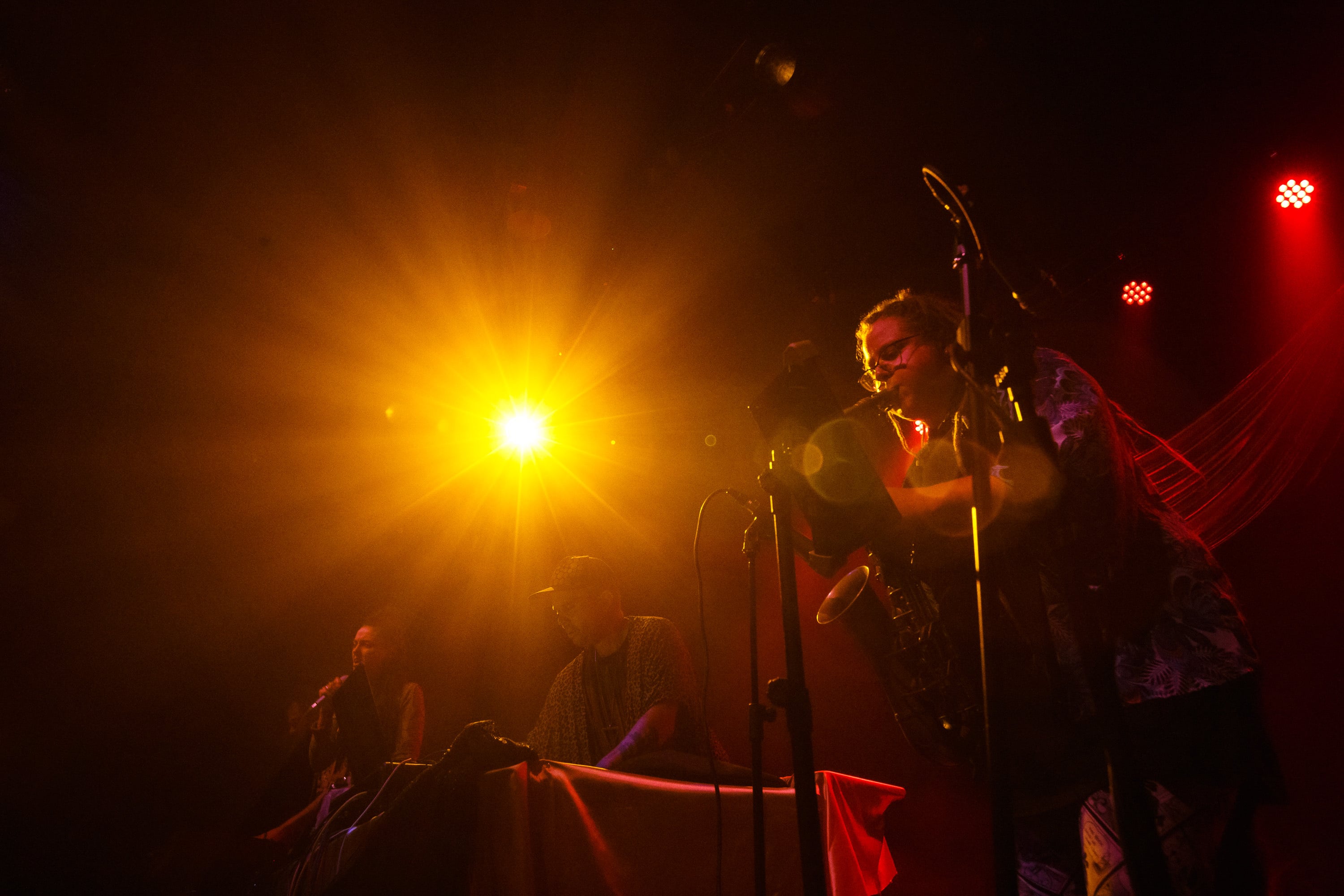 Singer backlit by a golden stage light.