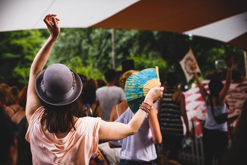 Dancer with a raised hand in a festival crowd.