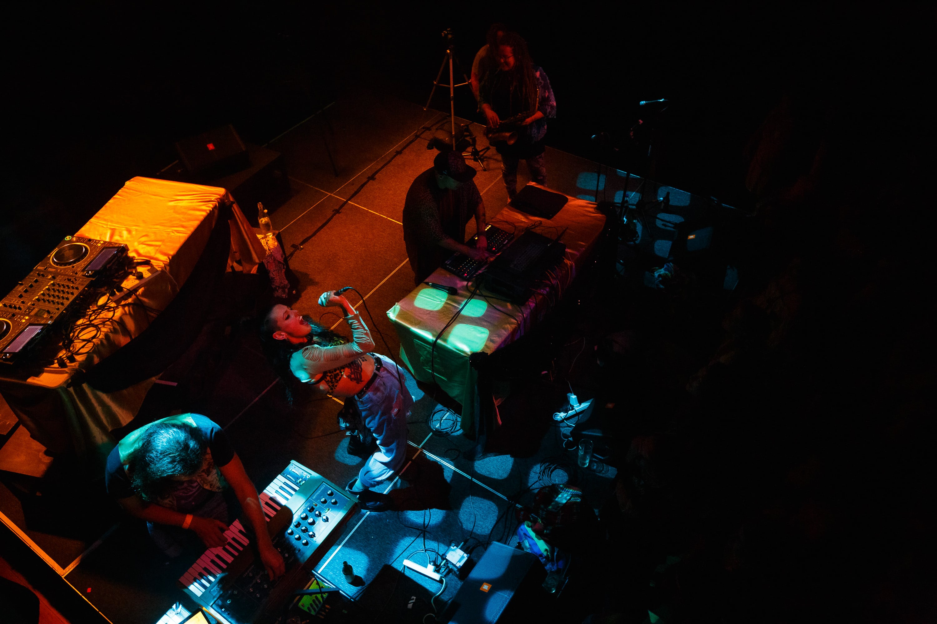Electronic musician surrounded by gear, seen from above.