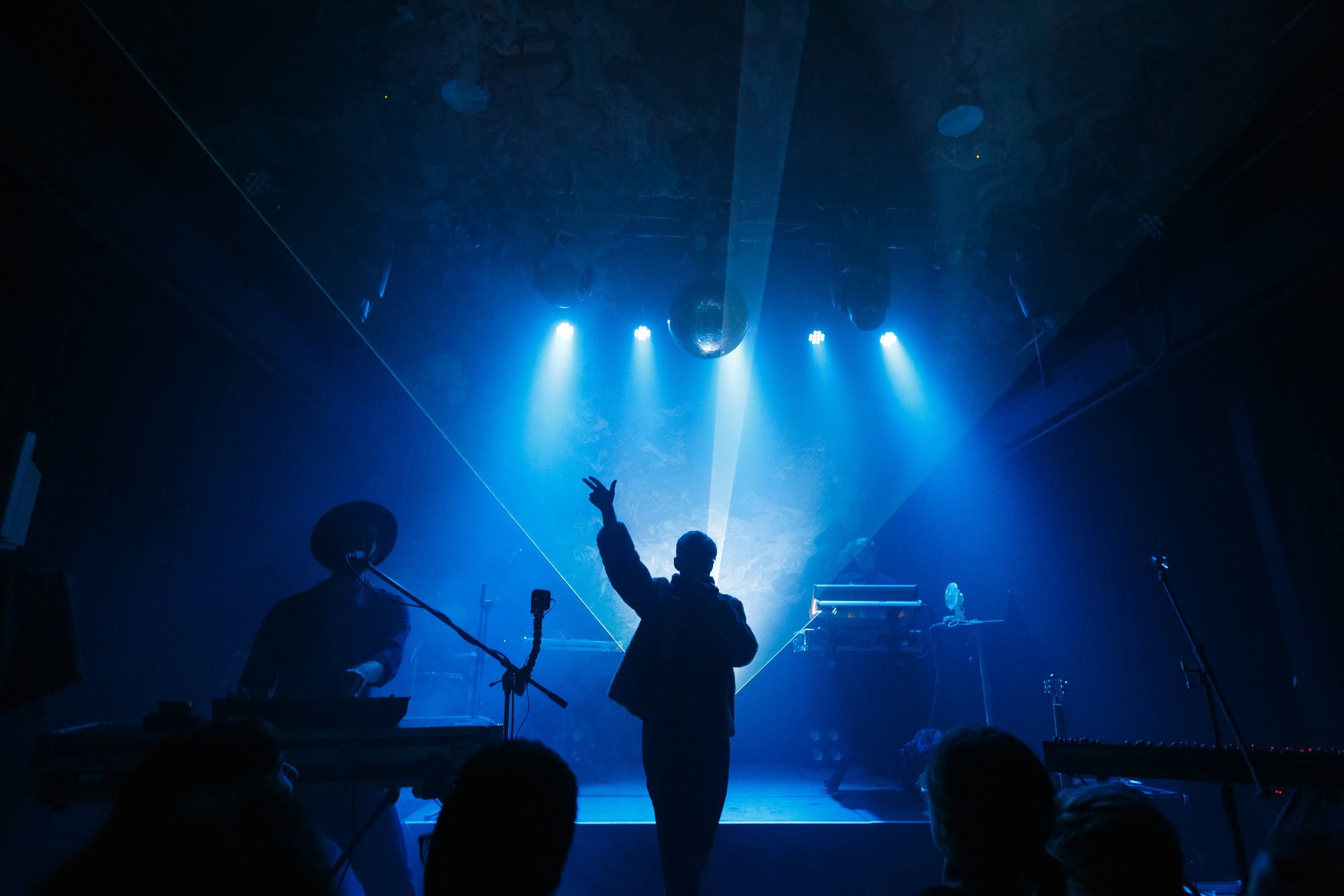 Silhouetted performer under a blue spotlight.