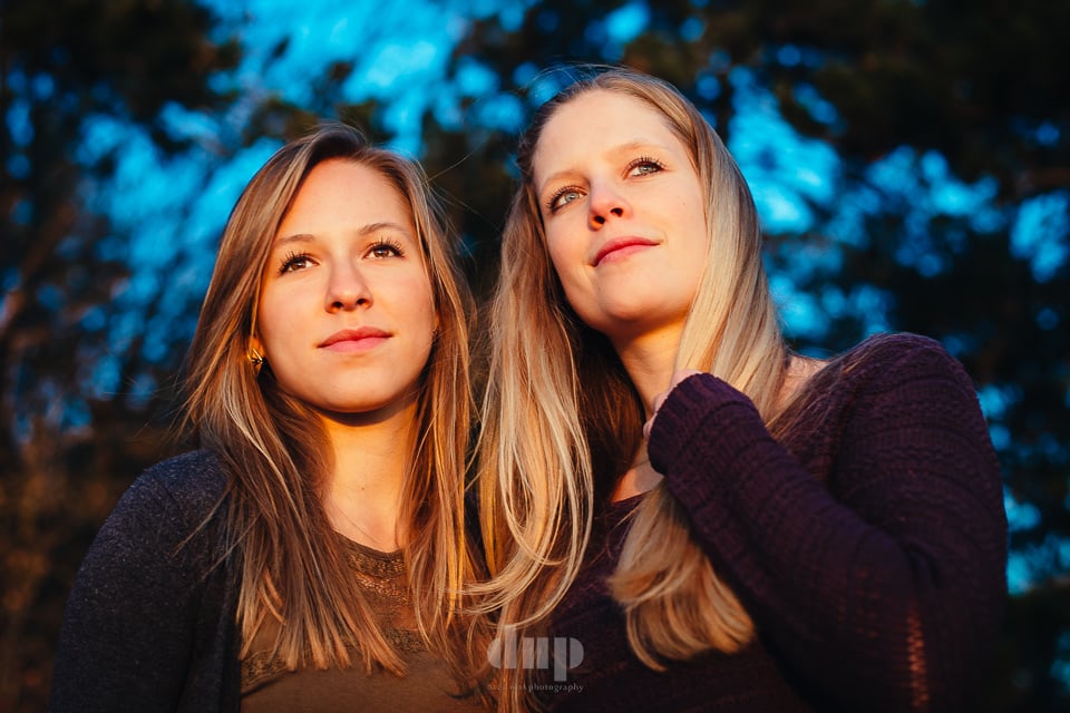 Two sisters side by side in warm evening light.
