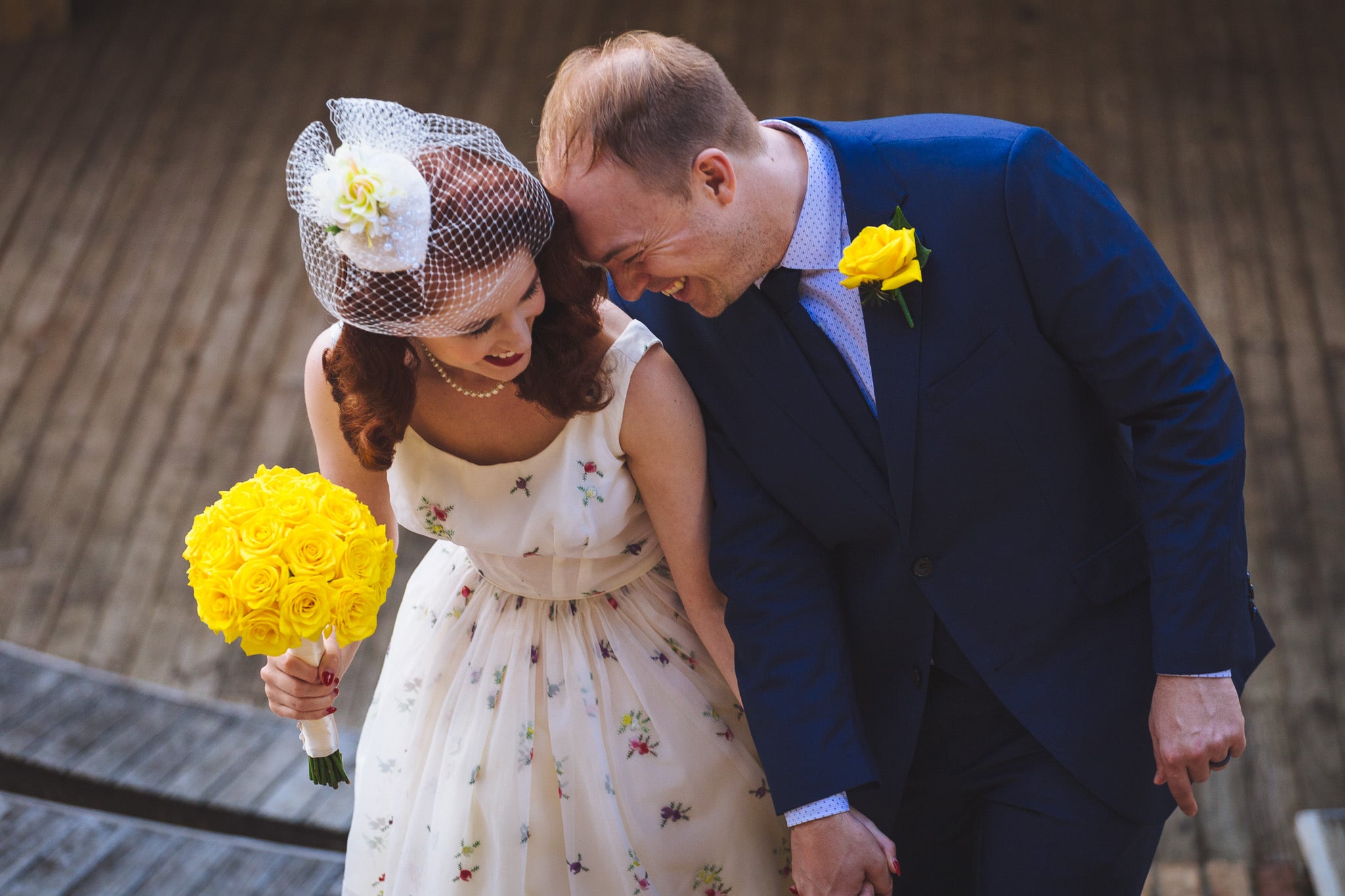 Couple leaning in together, yellow roses in hand.