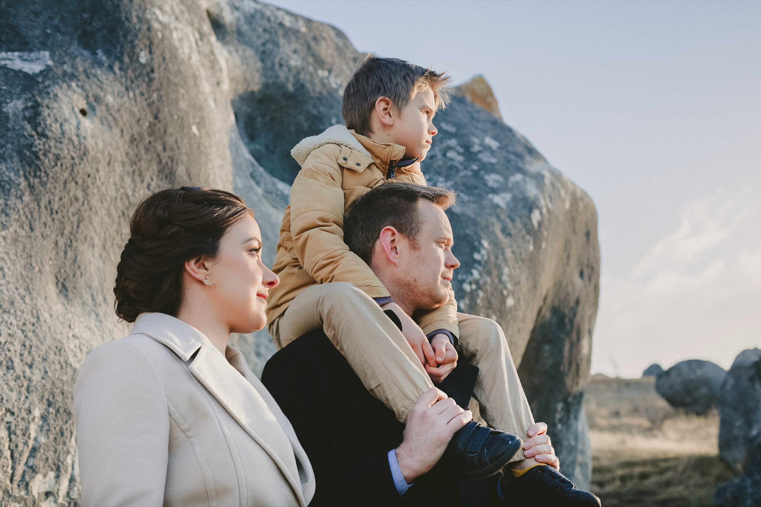 Family portrait with a boy on his father’s shoulders.