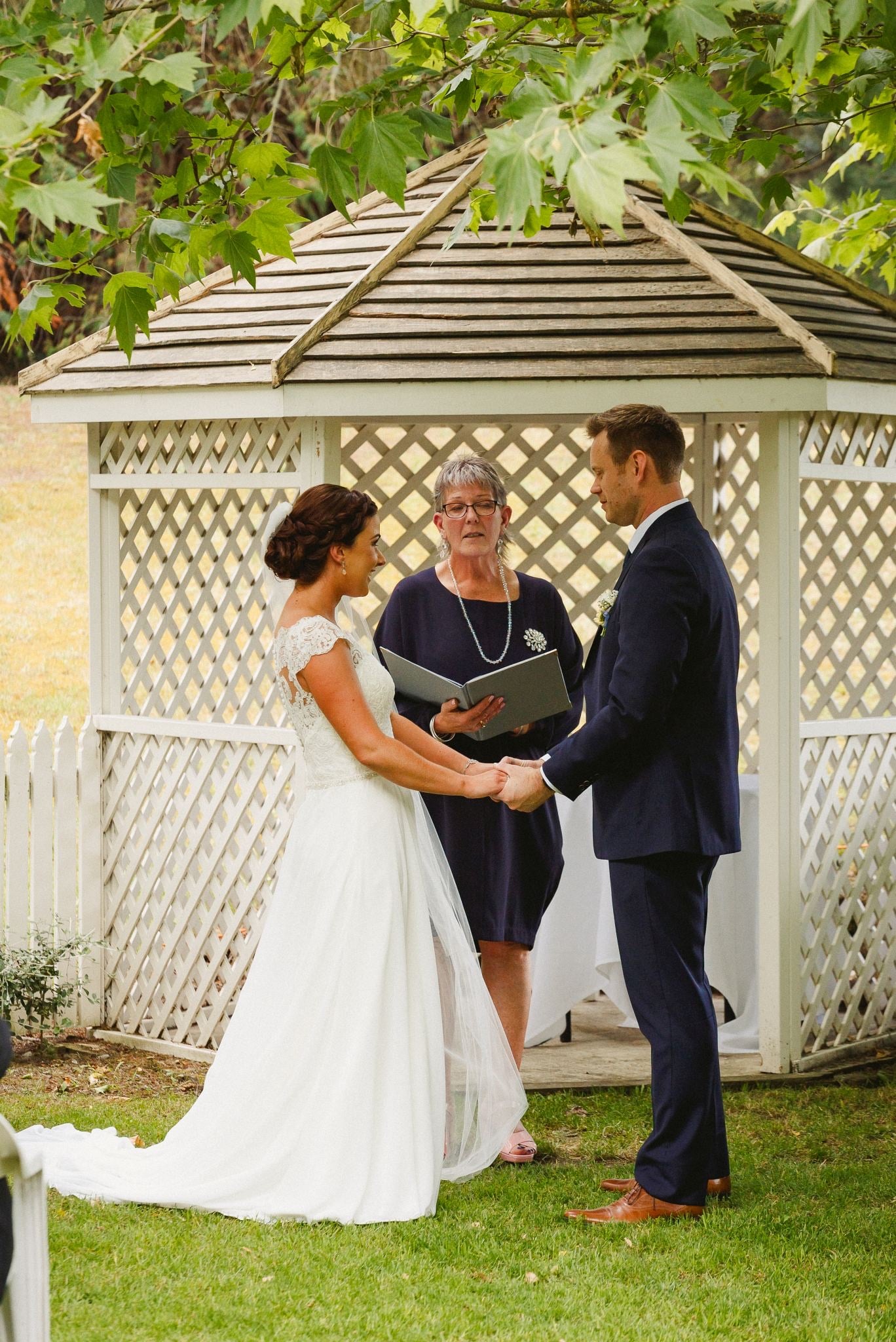 Vows exchanged in a white garden gazebo.