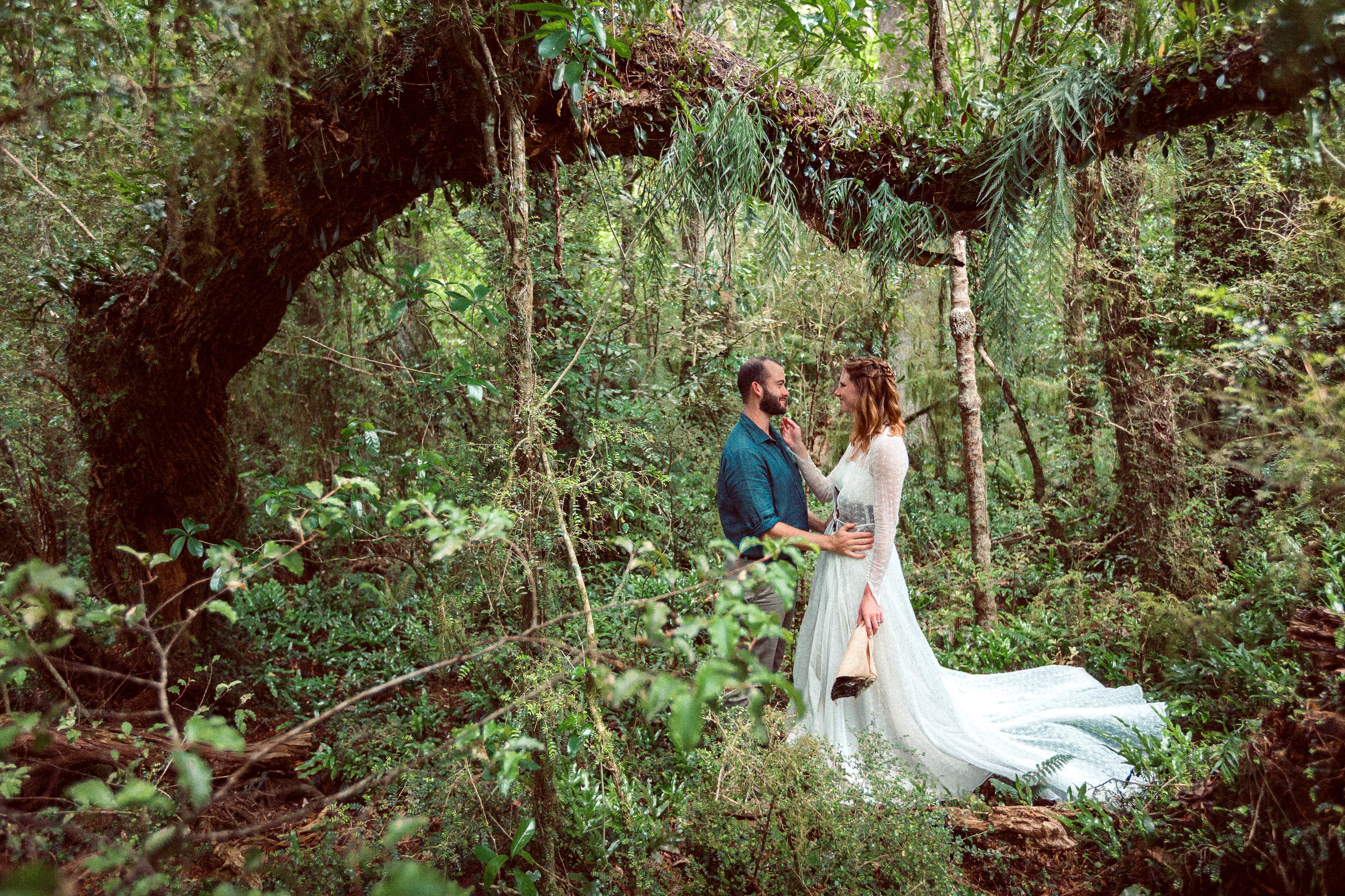 Couple standing in dense native forest.