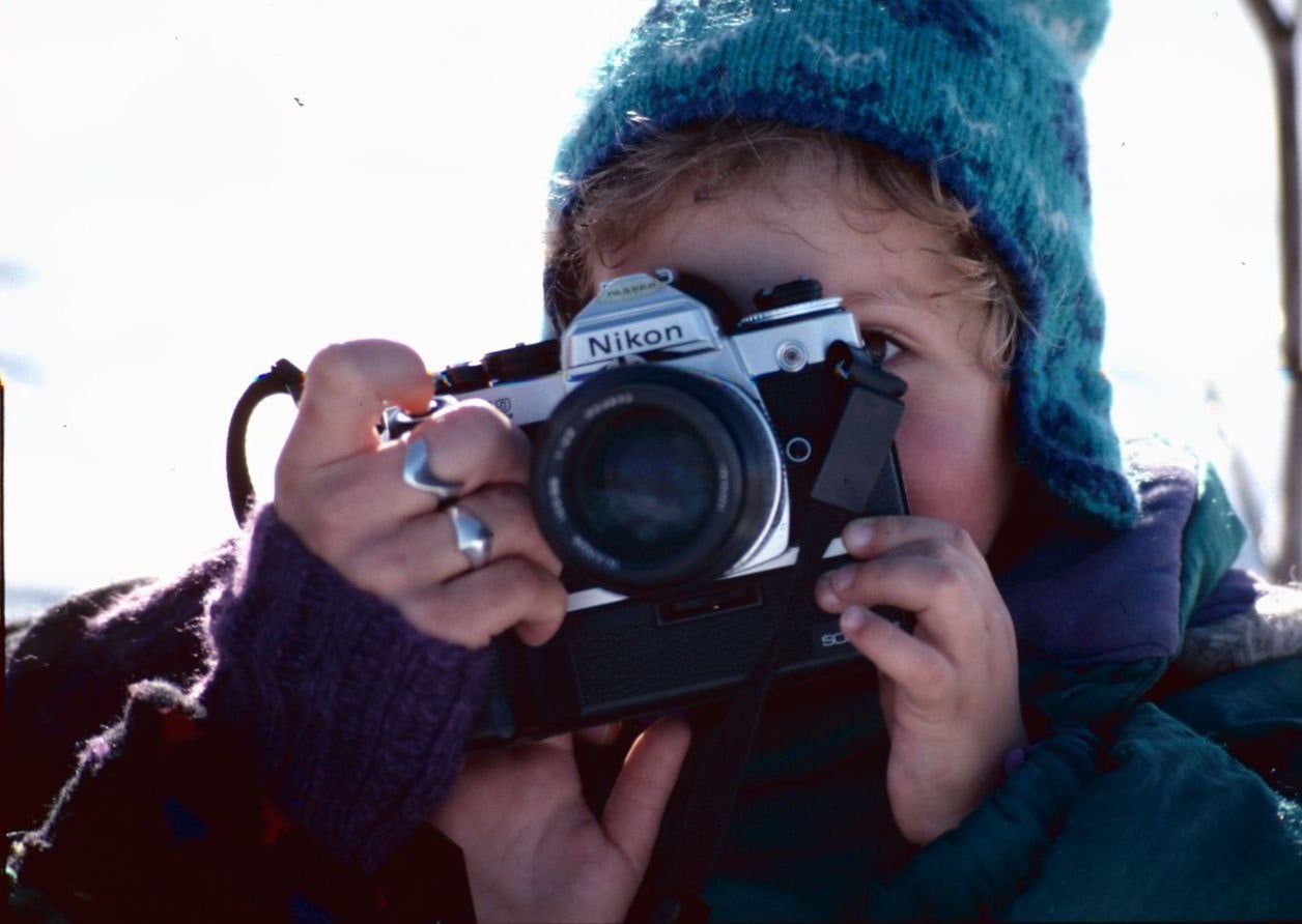 David as a child, looking through a Nikon film camera.